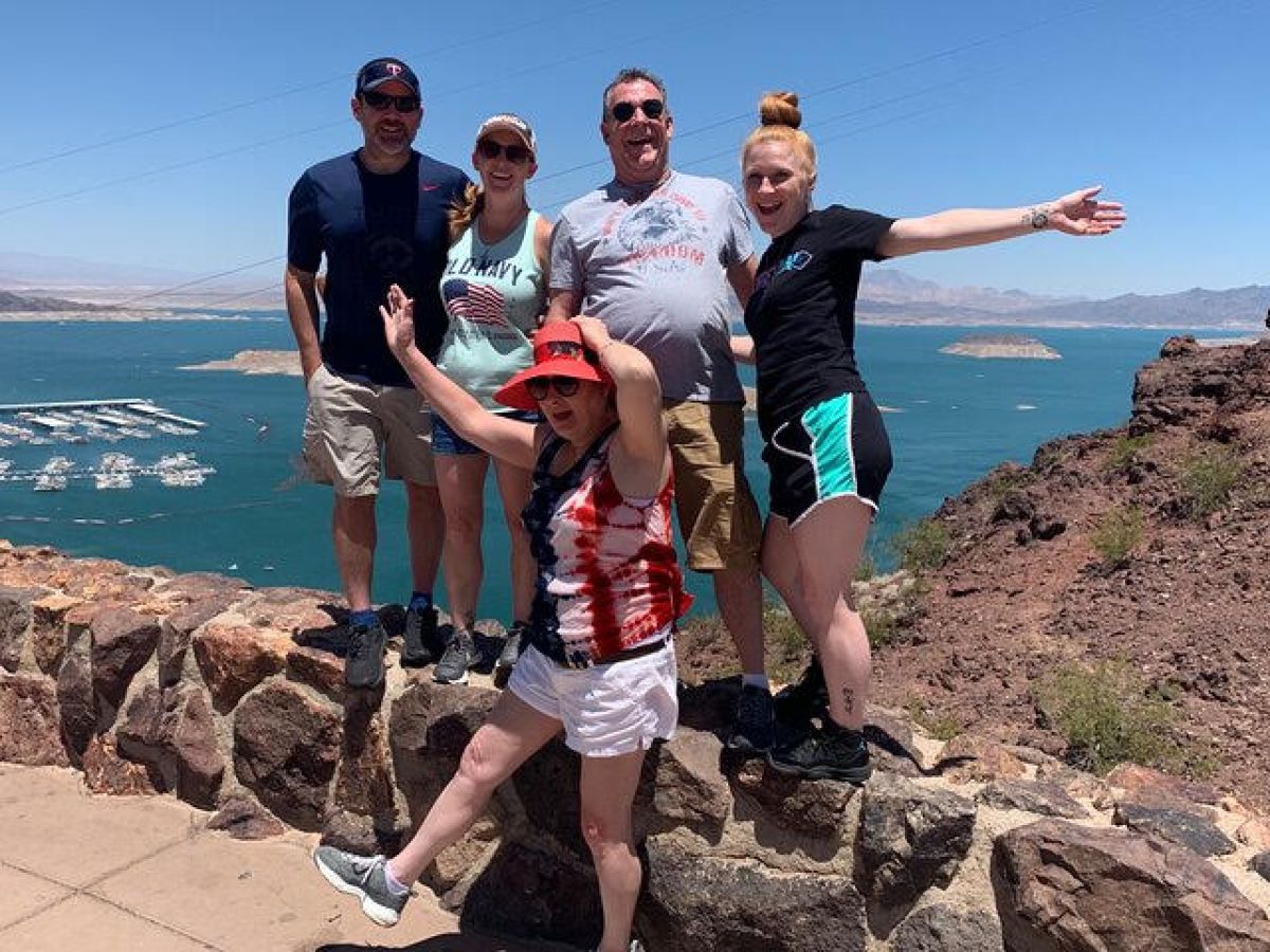 a group of people standing on a rock wall posing for a picture