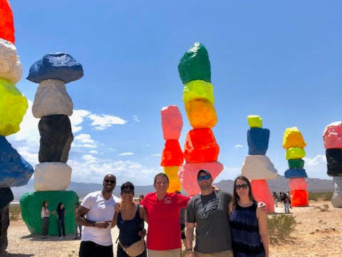 a group of people standing in front of colorful rocks